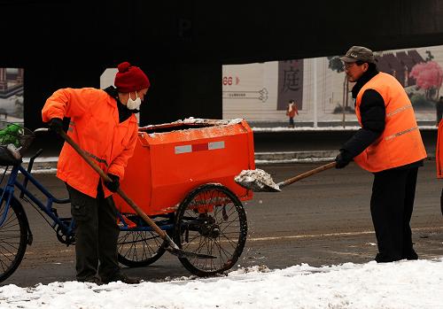 1月21日,環(huán)衛(wèi)工人在石家莊市中華大街清理路邊積雪。新華社發(fā)(朱旭東 攝)