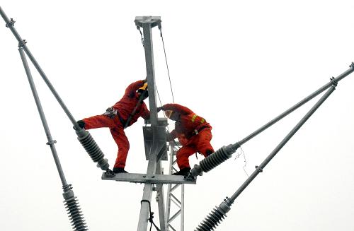 1月22日,兩名工人在將接觸網(wǎng)線(xiàn)腕臂調(diào)整到位。新華社記者 王頌 攝
