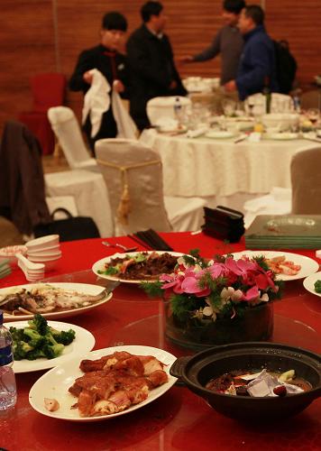 1月16日,在年會酒席結束時,餐桌上還留著很多大菜。服務員告訴記者,近來參加年會的客人大多不會把剩下的食物帶走。當晚,一家外資藥企在上海一家五星級酒店舉行年會,30桌酒席,餐飲標準是8冷菜12熱菜1湯加餐后水果,每桌4800元。酒席過半大部分員工都忙于參加年會的表演和抽獎活動,半數(shù)的熱菜都幾乎沒動,因為當晚所有員工都入住該酒店,所以也沒有人將吃剩的食物打包。據(jù)這家五星級酒店餐飲部工作人員介紹,臨近歲末,公司年會的宴會每周都有3至4場,每場的規(guī)模10桌至50桌不等,浪費的食物在四成以上。新華社記者 聶建江 攝