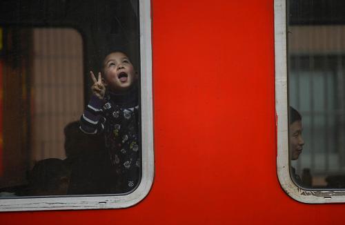 1月22日,浙江寧波開往安徽蚌埠的列車??亢贾莼疖囌緯r(shí),一名小朋友靠在車窗邊玩耍。新華社記者 韓傳號(hào) 攝
