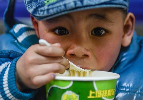 1月22日,5歲的趙永春在杭州火車站候車時(shí)吃方便面。他的老家在陜西西安,父母在浙江義烏打工。新華社記者 韓傳號(hào) 攝