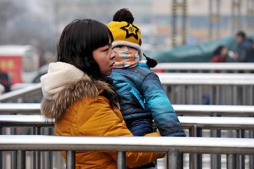 1月22日,在太原火車站,一位旅客抱著孩子進站乘車。