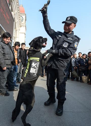 1月25日,鐵路警察在向旅客展示警犬的工作。新華社記者 程敏 攝