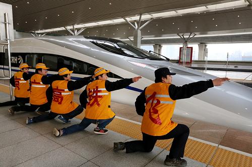 在鄭州東站候車區(qū),幾名鐵路職工擺出“航母Style”的動(dòng)作,為高鐵列車送行(2012年12月26日攝)。截至2013年1月25日,京廣高鐵開通運(yùn)營(yíng)一個(gè)月,鄭州鐵路局管內(nèi)各站共安全運(yùn)送旅客52.3萬(wàn)人。京廣高鐵開行以來(lái),沿線鐵路部門制定了風(fēng)雪、霧霾等自然災(zāi)害下的應(yīng)急方案,為高鐵安全開行和應(yīng)急故障處理提供了有力的保證。除因嚴(yán)重霧霾等惡劣天氣部分高鐵進(jìn)行降速運(yùn)行外,其余高鐵均實(shí)現(xiàn)安全正點(diǎn)運(yùn)行。新華社記者王頌攝