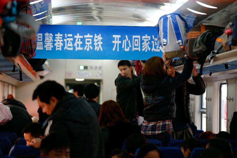 1月26日,在北京西站,乘客在車廂內(nèi)擺放行李。新華社記者 張宇 攝