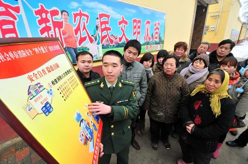 2月5日,在河北省任縣南西社區(qū),任縣武警消防大隊(duì)參謀陳英輝(前左)在向群眾講解消防安全常識(shí)。新華社發(fā)(朱旭東攝)
