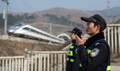 2月10日,武漢鐵路公安處橫店東派出所的鐵路警察張浩(右)和李航(左)在李集警務區(qū)接車。武漢鐵路公安處橫店東派出所是一個只有十多名干警的基層鐵路警察派出所,負責著京廣高鐵上88公里的線路管控工作,轄區(qū)地處偏僻,卻有著18個隧道、45座橋梁,鐵路兩邊分布著42個行政村,自然條件和人員情況復雜。春節(jié)期間,值班警察每天都要進行巡線,守護高鐵的安全。新華社記者 程敏 攝