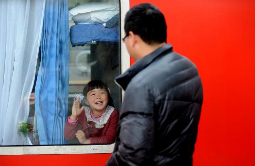 2月17日,在合肥火車站,一名小旅客隔著車窗和親人告別。新華社記者劉軍喜攝