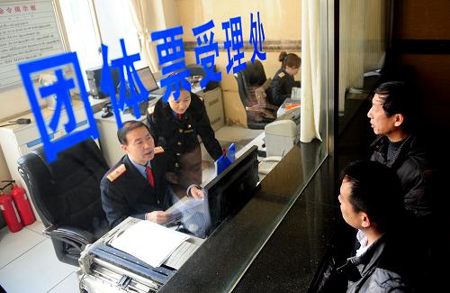 2月17日,在蘭州火車站團(tuán)體票受理處,來自甘肅省甘谷縣愛佳電腦培訓(xùn)學(xué)校的兩名工作人員(右)在為當(dāng)?shù)貏趧?wù)輸出的農(nóng)民工辦理團(tuán)體火車票。新華社記者 張錳 攝