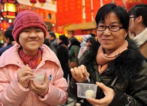 2月24日,游客在現(xiàn)場品嘗元宵。新華社發(fā)(張晨霖 攝)