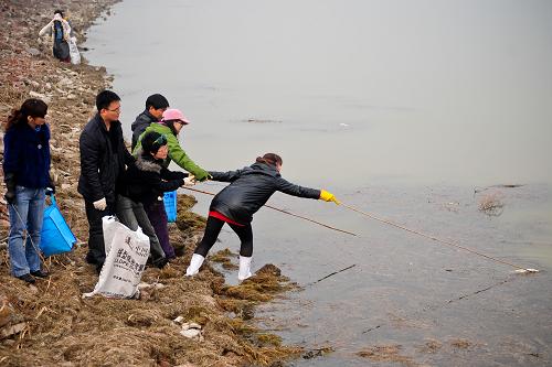 3月17日,志愿者們在打撈水中的漂浮垃圾和死魚。新華社記者 張超群 攝