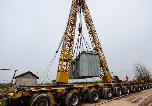 3月19日,吊車將397噸的變壓器吊上液壓平板車。新華社記者 徐昱 攝