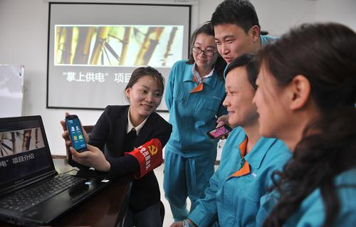 3月19日,江蘇揚(yáng)州供電公司工作人員向一家企業(yè)客戶的工作人員展示“掌上供電”系統(tǒng)的使用方法。新華社發(fā)(濮良平 攝)