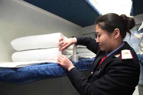 在k154次列車的臥鋪車廂內,列車員整理剩余臥鋪(3月19日攝)。新華社發(fā)(張強 攝)