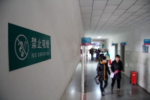 3月31日,患者從河北省唐縣白求恩紀(jì)念醫(yī)院內(nèi)掛著禁煙標(biāo)識(shí)的走廊經(jīng)過(guò)。新華社發(fā)(朱旭東攝)
