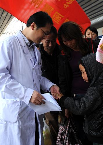 4月15日,清華大學(xué)第一附屬醫(yī)院副主任醫(yī)師潘廣玉在北京西站核對(duì)患兒的信息。新華社記者唐召明攝