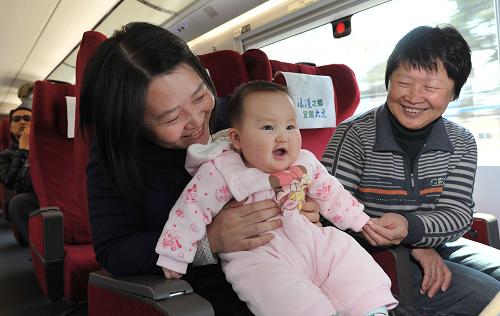 4月20日,沈陽市民邊曉羽(左)帶著女兒和母親乘坐大連至長春的動(dòng)車回沈陽老家。新華社發(fā)(劉德斌 攝)