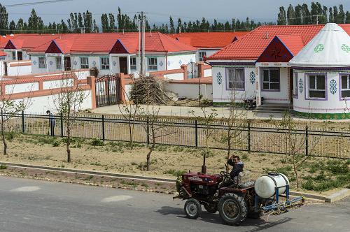 在新疆伊犁鞏留縣阿克吐別克鎮(zhèn)的哈雷新村定居小區(qū)旁,一位牧民駕駛拖拉機從小區(qū)旁經(jīng)過(5月11日攝)。近年來,一個個新建的定居興牧區(qū),圍繞在靜謐的伊犁河旁,過去逐水草而居的牧民正逐步遷往這些定居點。隨著游牧生活向定居生活的轉(zhuǎn)變,不少牧民通過遠程教育、入村培訓(xùn)等方式學(xué)習(xí)了新本領(lǐng),掌握了新技術(shù),富余勞動力成為家庭增收“生力軍”。在定居小區(qū)周邊,衛(wèi)生院、學(xué)校和幼兒園等配套設(shè)施的建設(shè),也讓牧民的醫(yī)療和教育發(fā)生了質(zhì)的改變。 中央新疆工作座談會和新一輪援疆開展以來,新疆伊犁哈薩克自治州和支援地江蘇省把安居富民和定居興牧作為改善民生的首要任務(wù)。兩年多來,江蘇省在援疆民生工程上的投入占援疆資金總數(shù)的75%,其中安居富民、定居興牧、棚戶區(qū)改造投入近15億元,受惠牧民達到8274戶。新華社記者 王菲攝