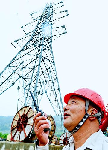 5月15日,國(guó)家電網(wǎng)福建省送變電工程公司現(xiàn)場(chǎng)指揮員在寧德核電站架線工地指揮施工。新華社記者張國(guó)俊攝