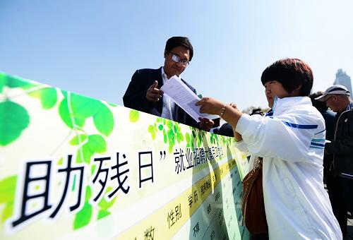 5月16日,一位殘疾人(右)在殘疾人招聘大集上和某愛心企業(yè)招聘負(fù)責(zé)人交流。新華社記者 王凱攝