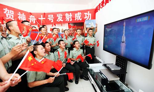 6月11日,在濟(jì)南軍區(qū)某部文化活動(dòng)中心,官兵觀看神舟十號(hào)載人飛船發(fā)射的電視直播。新華社發(fā)(梁志杰 攝)