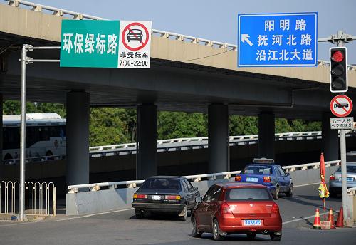這是南昌市八一大橋引橋位置設(shè)置的環(huán)保限行指示牌(6月12日攝)。6月開始,江西南昌市對“黃標(biāo)車”和“無標(biāo)車”采取限行措施,限行時間為每日7時至22時,限行區(qū)域包括南昌主城區(qū)和主干道,第一個月為新規(guī)過渡月,以宣傳教育為主。7月1日起,違規(guī)者將受到罰款200元和扣2分的處罰。目前,南昌市各主要路段已安裝了78塊非綠標(biāo)車限行指示牌。據(jù)了解,“黃標(biāo)車”是指污染物排放達(dá)不到國I排放標(biāo)準(zhǔn)的汽油車和達(dá)不到國Ⅲ排放標(biāo)準(zhǔn)的柴油車,“無標(biāo)車”指未取得環(huán)保標(biāo)志和標(biāo)志已過期的機(jī)動車。南昌對環(huán)保檢驗合格的機(jī)動車發(fā)放綠色或黃色兩種標(biāo)志。裝用點燃式發(fā)動機(jī)汽車達(dá)到國Ⅰ及以上標(biāo)準(zhǔn)的、裝用壓燃式發(fā)動機(jī)達(dá)到國Ⅲ及以上標(biāo)準(zhǔn)的,核發(fā)綠色環(huán)保檢驗合格標(biāo)志;未達(dá)到上述標(biāo)準(zhǔn)的,核發(fā)黃色環(huán)保檢驗合格標(biāo)志。新華社記者 周科 攝