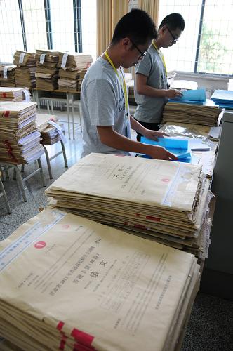 6月13日,在西北師范大學評卷點,兩名評卷工作人員對試卷進行歸類整理。新華社記者 范培珅 攝