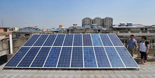 劉銳(左)和妻子在自家樓頂查看太陽能電池板(6月14日攝)。6月8日,在電力工作人員驗收調(diào)試下,湖南湘潭市民劉銳自建的2.4千瓦功率“私家電站”正式并入國家電網(wǎng)。這是湖南第一個實現(xiàn)并網(wǎng)發(fā)電的“家庭光伏電站”。劉銳的“私家電站”由20塊太陽能電池板、一個逆變器、一個電能表及開關(guān)、電線等組件組成,占地約20平方米,總造價近4萬元。電站日平均發(fā)電量約10到12度之間,而劉銳的家庭用電量一般在每天4度左右,多余的電量賣給國家電網(wǎng)?,F(xiàn)有政策條件下投資回報的周期很長,劉銳說:“不是指望來賺錢,主要還是環(huán)保。”新華社記者 龍弘濤 攝