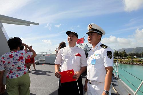 6月16日,在塞舌爾維多利亞港,一名艦員在哈爾濱艦上向前來參觀的當(dāng)?shù)厝A僑進(jìn)行講解。新華社記者 饒饒 攝