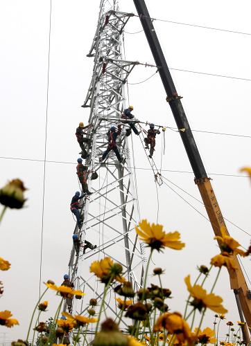 6月18日,國家電網(wǎng)山東莒南縣供電公司的工作人員冒著酷暑進(jìn)行電網(wǎng)升級。新華社發(fā)(胡順剛攝)