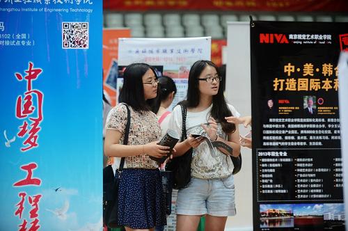 6月24日,兩名學(xué)生在江蘇省2013年普通高校招生咨詢(xún)會(huì)揚(yáng)州分會(huì)場(chǎng)上了解高校招生信息。新華社發(fā)(孟德龍 攝)