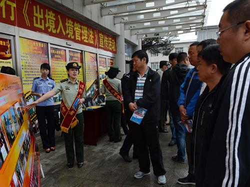 6月24日,吉林省圖們邊防檢查站人員向出入境游客宣傳即將實(shí)施的《中華人民共和國(guó)出境入境管理法》。新華社發(fā)(管清江 攝)