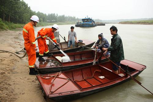 6月25日,消防隊(duì)員冒雨在渦河蒙城水域?yàn)闇舸坏拇裉峁┥钣盟a(bǔ)給。新華社發(fā)(胡衛(wèi)國(guó) 攝)