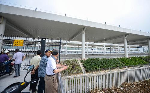 6月26日,湖州市民們?cè)诟哞F湖州站外觀看高鐵調(diào)試列車。新華社記者 徐昱 攝