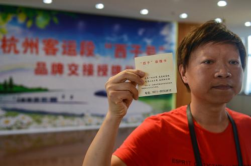 6月28日,“西子號(hào)”列車?yán)铣丝痛眈R翔展示自己收藏的“西子親情卡”。新華社記者 韓傳號(hào) 攝
