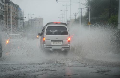 8月21日,臺(tái)州市天臺(tái)縣一輛面包車行駛在大雨中。新華社記者 徐昱 攝