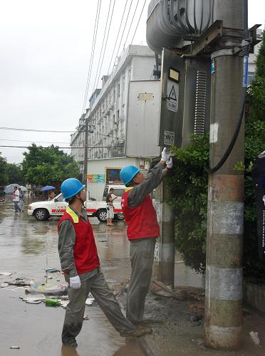 8月22日,瑞安電力黨員服務(wù)隊(duì)隊(duì)員在冒雨涉水檢查電力設(shè)備情況。新華社發(fā)(陳海卯?dāng)z)