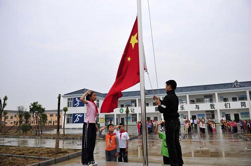 湖北省鄖縣安陽鎮(zhèn)搬遷到千里之外團風縣黃湖農(nóng)場移民安置點的移民孩子,在安置點新建的學校里升國旗。時間已經(jīng)過去了幾年,他們已經(jīng)融入了當?shù)氐纳睿?010年5月27日攝)。新華社記者 郝同前 攝