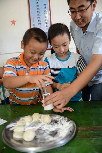 9月17日,余杭區(qū)供電公司的愛(ài)心志愿者和孩子們一起制作月餅。新華社記者 徐昱 攝