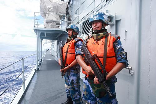 9月18日,在南太平洋某海域,中國海軍艦艇113編隊臨檢小組在演練中攜帶輕武器登臨商船實施檢查。新華社記者查春明攝