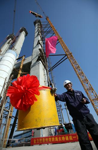 11月30日,在泉州灣跨海大橋施工現(xiàn)場(chǎng),一名建筑工人在指揮最后一罐混凝土升空。當(dāng)日,福建泉州灣跨海大橋高達(dá)157米的主塔實(shí)現(xiàn)順利封頂,比原計(jì)劃工期2014年1月20日提前了數(shù)十天。泉州灣跨海大橋全線約26公里,起于福建省晉江市南塘村,止于惠安縣塔埔樞紐互通立交,跨海大橋長(zhǎng)約12公里。目前,該項(xiàng)目路基土石方完成90%,下部結(jié)構(gòu)完成75%,上部結(jié)構(gòu)完成40%,預(yù)計(jì)2014年實(shí)現(xiàn)主橋合龍。新華社發(fā)(張九強(qiáng) 攝)