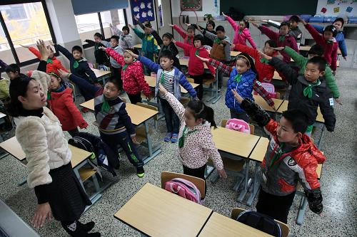 12月5日,上海中心氣象臺發(fā)布今年入冬以來首個大霧橙色預(yù)警,在上海金山區(qū)海棠小學(xué)二(7)班,學(xué)生們在老師的帶領(lǐng)下,做室內(nèi)課間操,消除疲勞,鍛煉身體。受長三角區(qū)域霧霾影響,上海從12月初起持續(xù)出現(xiàn)污染天氣。連日來,上海市教委下發(fā)通知,在校學(xué)生一律停止戶外活動;遲到、缺勤學(xué)生不作曠課處理,同時各區(qū)縣教育行政部門加強了對轄區(qū)內(nèi)相關(guān)學(xué)校的督查和指導(dǎo)工作,確保應(yīng)急響應(yīng)措施切實落實到位。新華社發(fā)(莊毅 攝)