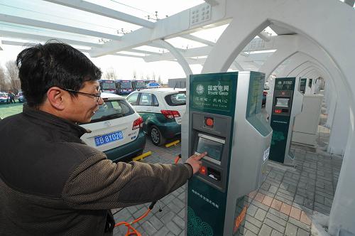 1月8日,司機張永吉在給自己駕駛的電動出租車充電。新華社記者 羅曉光 攝