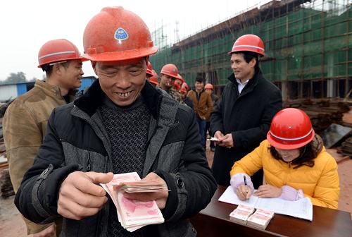1月11日,農民工鐘弼桂(左二)在江西省高安市工業(yè)園區(qū)的一個建筑工地上點算領到的工資。當日,江西省高安市工業(yè)園區(qū)的一個建筑工地上,125名農民工領到了由主管部門墊付的140萬元工錢。據悉,2013年江西省人民政府下發(fā)《關于建立健全保障農民工工資支付工作責任制的通知》,在全國率先以省政府名義建立責任制、實行通報制度。對直屬用人單位拖欠工資不能及時支付的,由主管部門或主要出資單位先行墊付。江西省已設立12333投訴舉報熱線,并將在近期組成聯(lián)合督查組,赴部分地市進行重點督查并將對各地、各部門春節(jié)前保障農民工工資支付工作情況進行通報,嚴厲打擊用人單位欠薪違法行為。新華社記者 宋振平 攝