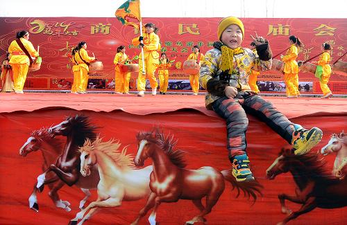 1月26日,一位小男孩在廟會(huì)的露天舞臺(tái)上玩耍。新華社記者 王頌 攝