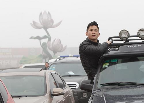 1月30日,在因大霧封閉的江西省九江市荷花垅高速收費站外,一名車主盼著車輛放行。新華社發(fā)(沈俊峰 攝)