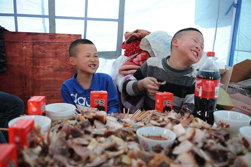 1月30日,在貴州鎮(zhèn)遠(yuǎn)縣報(bào)京鄉(xiāng)報(bào)京村,兄弟倆一起上桌吃年夜飯。30日記者在報(bào)京村采訪看到,一片碎石瓦礫上已經(jīng)搭建起了200多頂救災(zāi)帳篷,失去家園的村民們臨時(shí)居住在帳篷里,家家戶戶都在殺雞煮肉做年夜飯,盡管火災(zāi)的煙氣還沒(méi)完全散去,但村里仍然彌漫著濃濃的年味。25日23時(shí)許,一場(chǎng)大火侵襲了報(bào)京村,這個(gè)坐落在山坡上的侗族村寨陷入一片火海。據(jù)統(tǒng)計(jì),全村148棟房屋被燒毀,296戶1184名村民受災(zāi)。新華社記者 王念 攝
