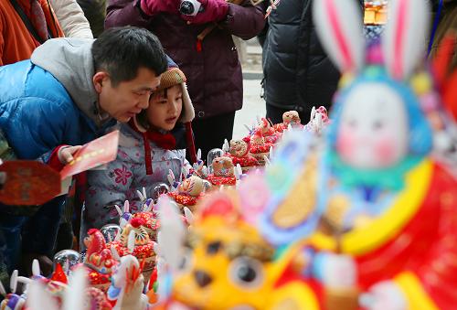 1月31日,游客在東岳廟春節(jié)廟會上觀賞泥塑十二生肖和“兔爺”。當(dāng)日,第十六屆北京東岳廟春節(jié)文化廟會開幕,眾多市民和游客到廟會賞民俗過大年。新華社記者 侯俊 攝