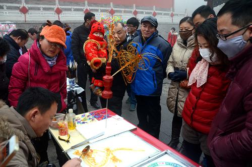 1月31日,市民和游客在鄭州文廟廟會觀看糖人的制作過程。新華社記者 李安 攝