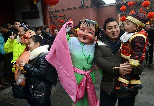 1月31日,在鄭州城隍廟內,游客在與表演民間社火的演員合影留念。新華社記者 王頌 攝